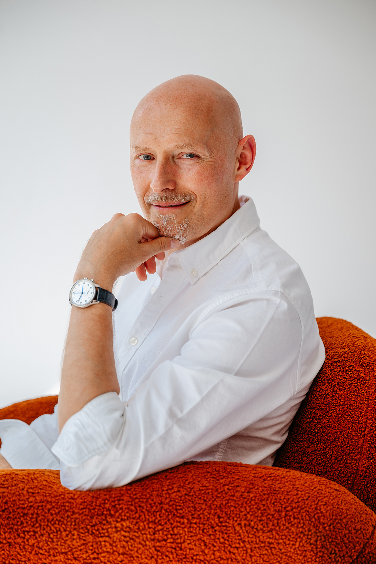 Dr. Piechowski, neurologist and functional medicine doctor, seated in an orange armchair